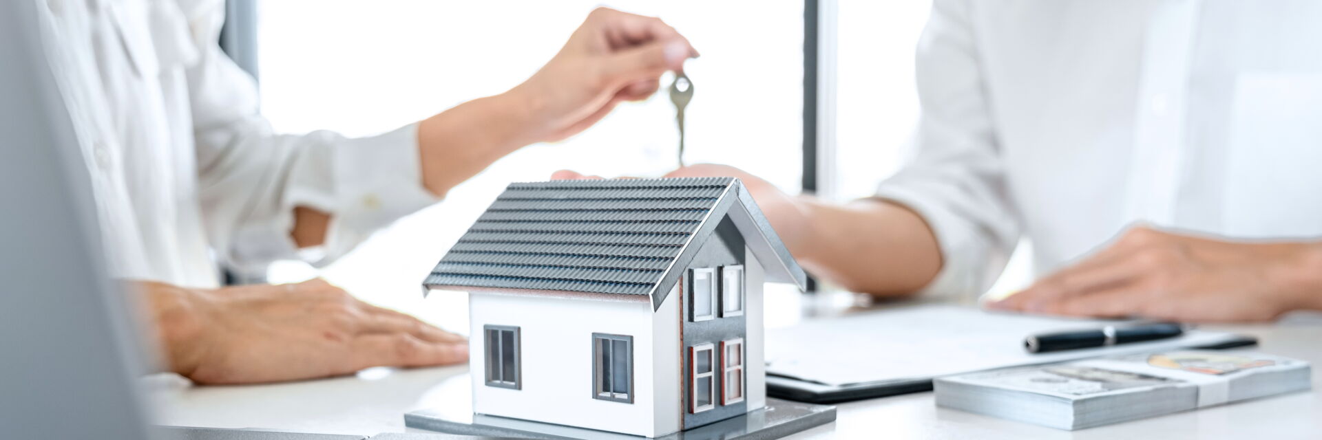 Symbolische Schlüsselübergabe für ein Hausmodell in Bautzen. Immobilien Anders GmbH – Ihr Partner für den erfolgreichen Immobilienkauf.