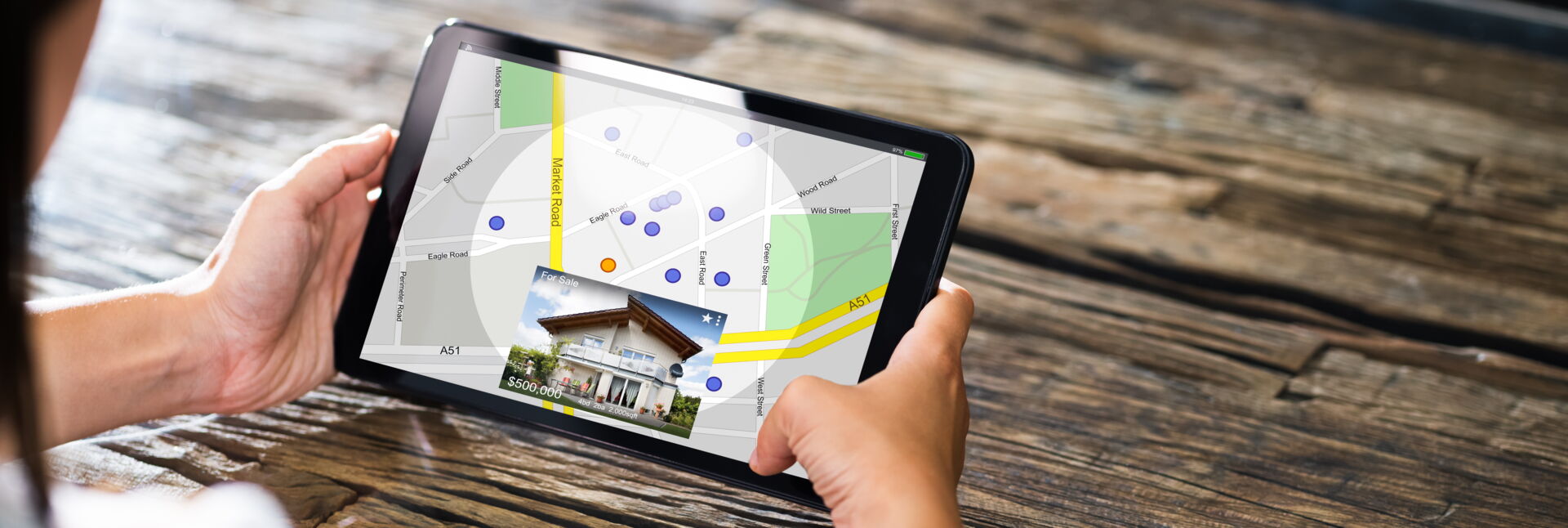 Eine Person betrachtet Immobilienangebote auf einer digitalen Karte von Bautzen auf einem Tablet. Immobilien Anders GmbH präsentiert lokale Objekte.